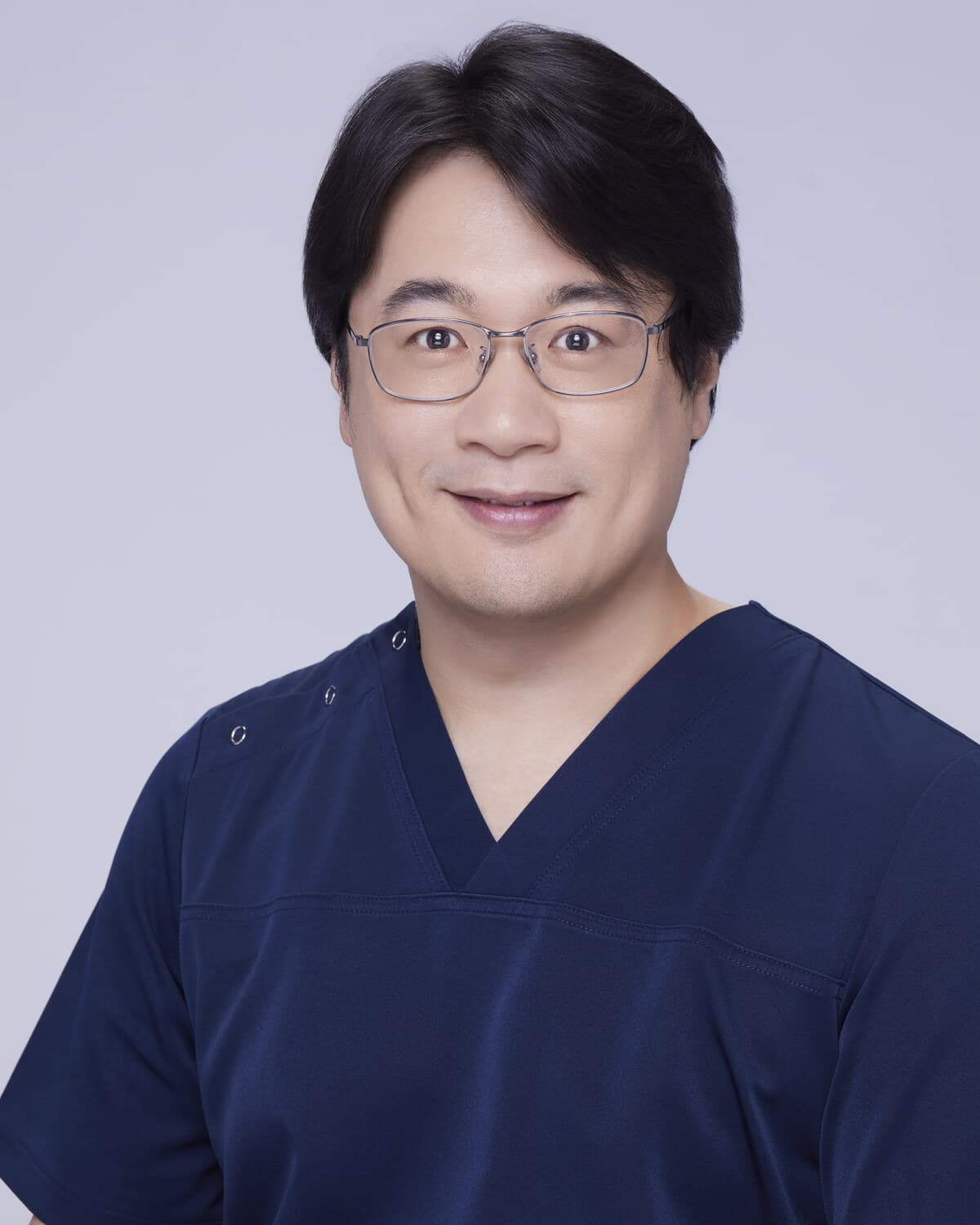 劉達儒醫師身穿深藍手術服的正面半身照