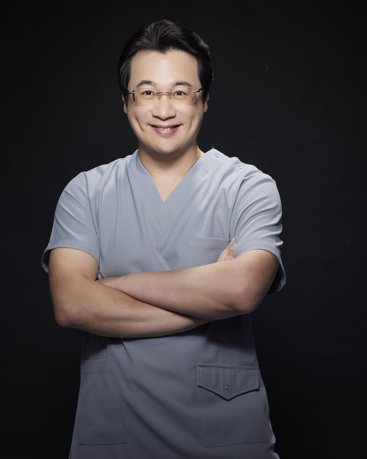 劉達儒醫師身穿灰色手術服、雙手交叉站立的形象照